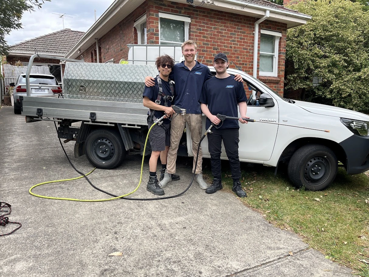 three team members of eastern pressure in-front of company car